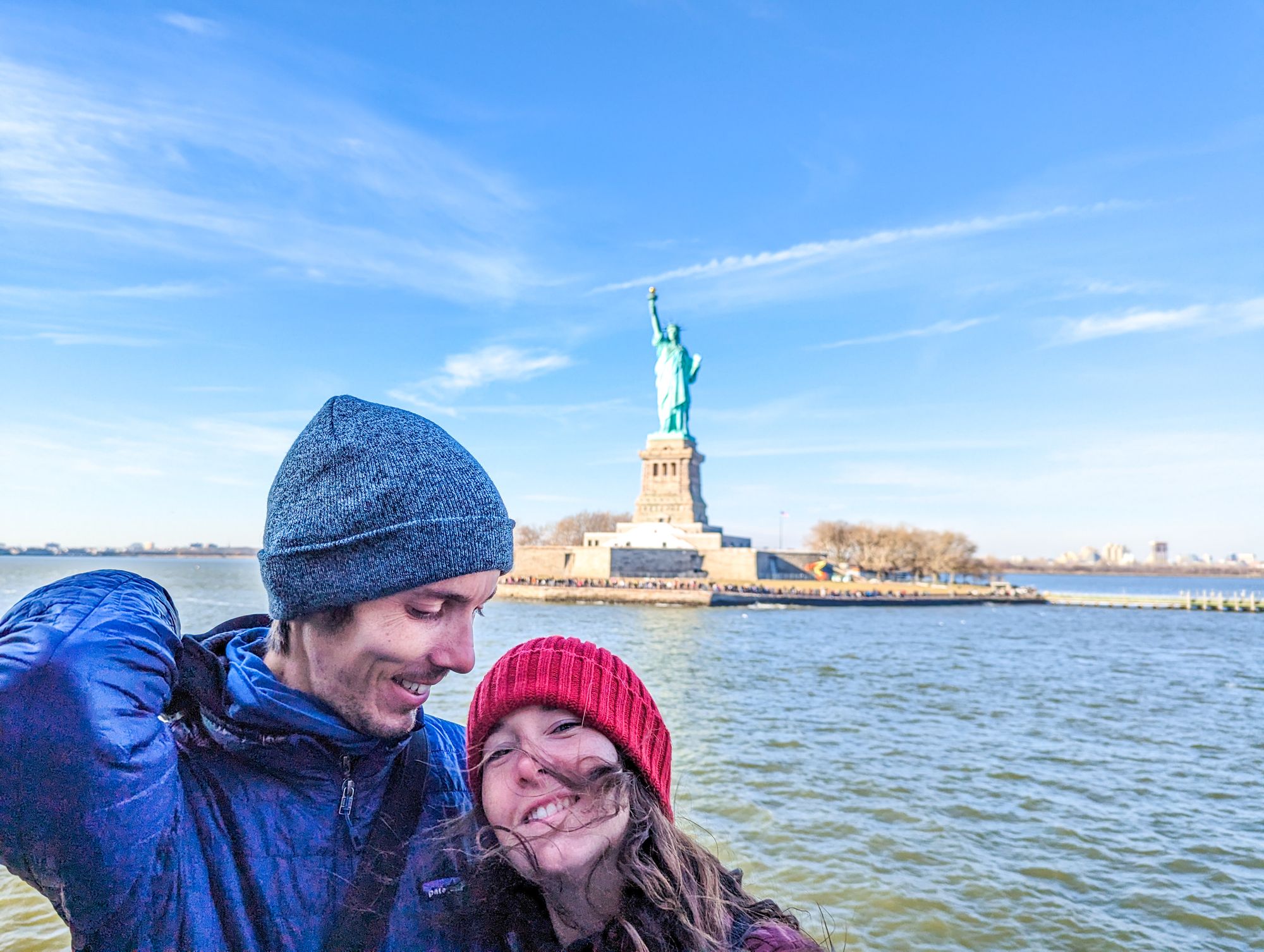 Couple qui prend un selfie devant la Statue de la Liberté