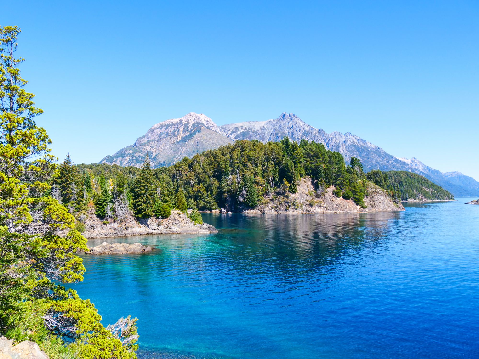 Lac avec la forêt et les montagnes en fond